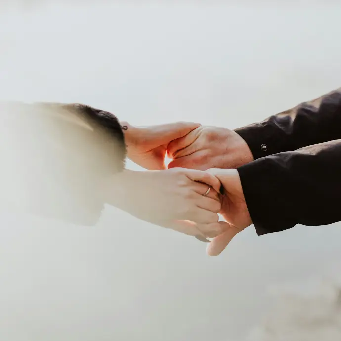 a couple holding hands while standing next to each other