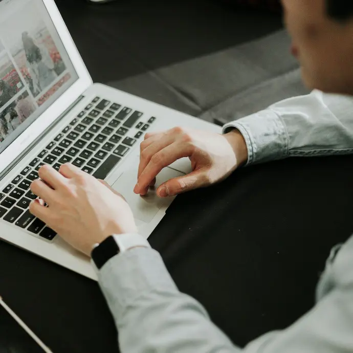 a man sitting at a table using a laptop computer