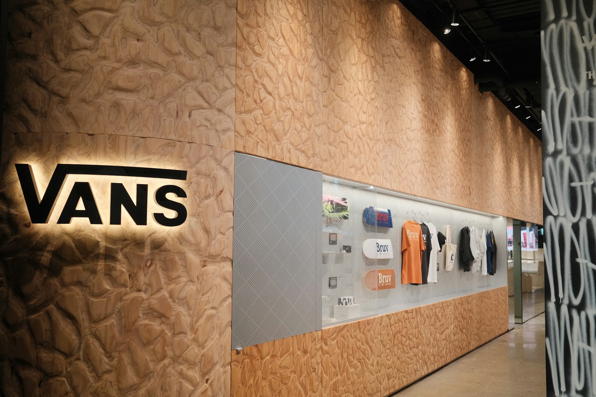 Vans logo on textured wall with displayed merchandise